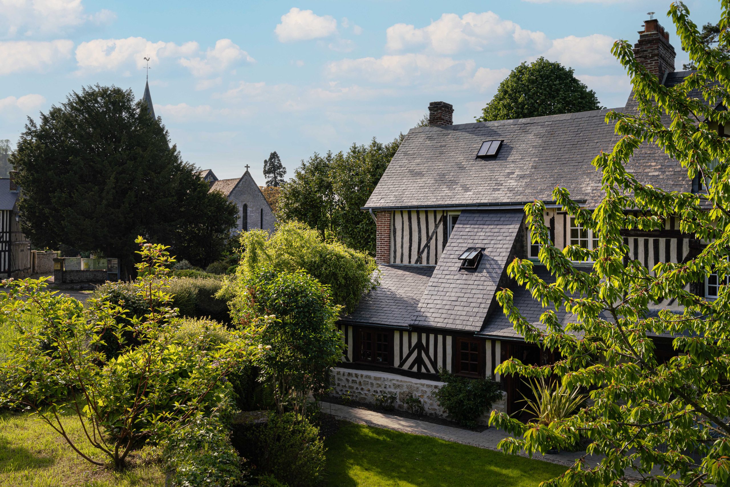 maison en pierre avec un toit en ardoise, entourée de verdure - cottage honfleur